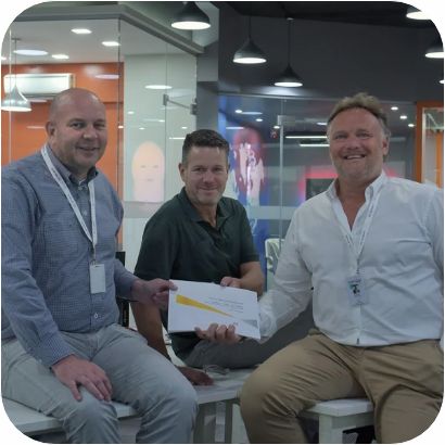 WorldEmp-oprichters Frank Korf, Peter van Londen en COO Jasper Fortuin in gesprek tijdens een bijeenkomst in een moderne werkruimte, waarmee de internationale samenwerking van het bedrijf wordt benadrukt.